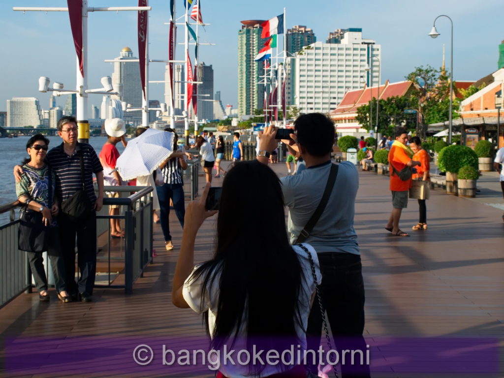 Turisti intenti a scattare foto sulla banchina dell'Asiatique.